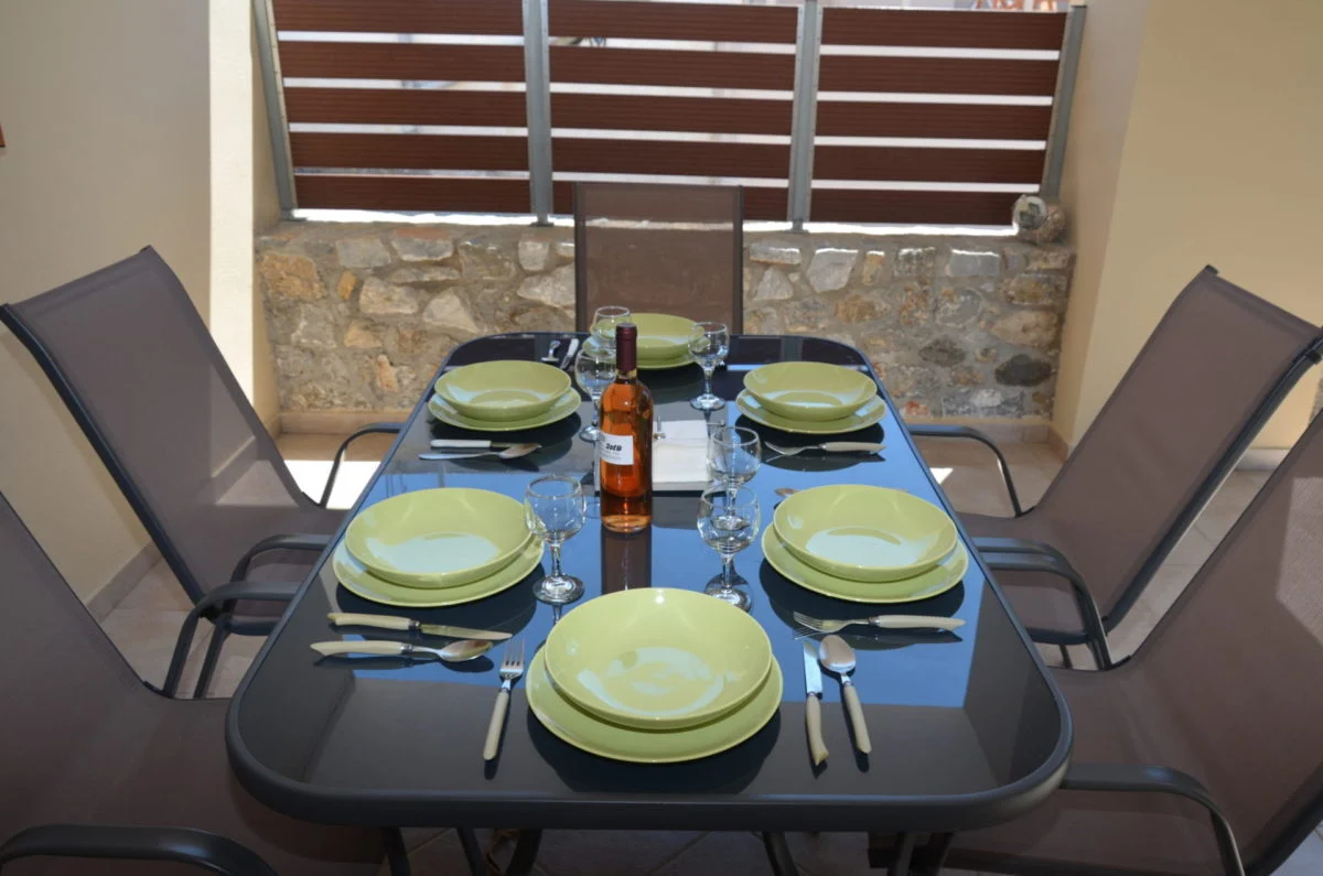Villa Ciel outdoor dining table blue place settings stone wall